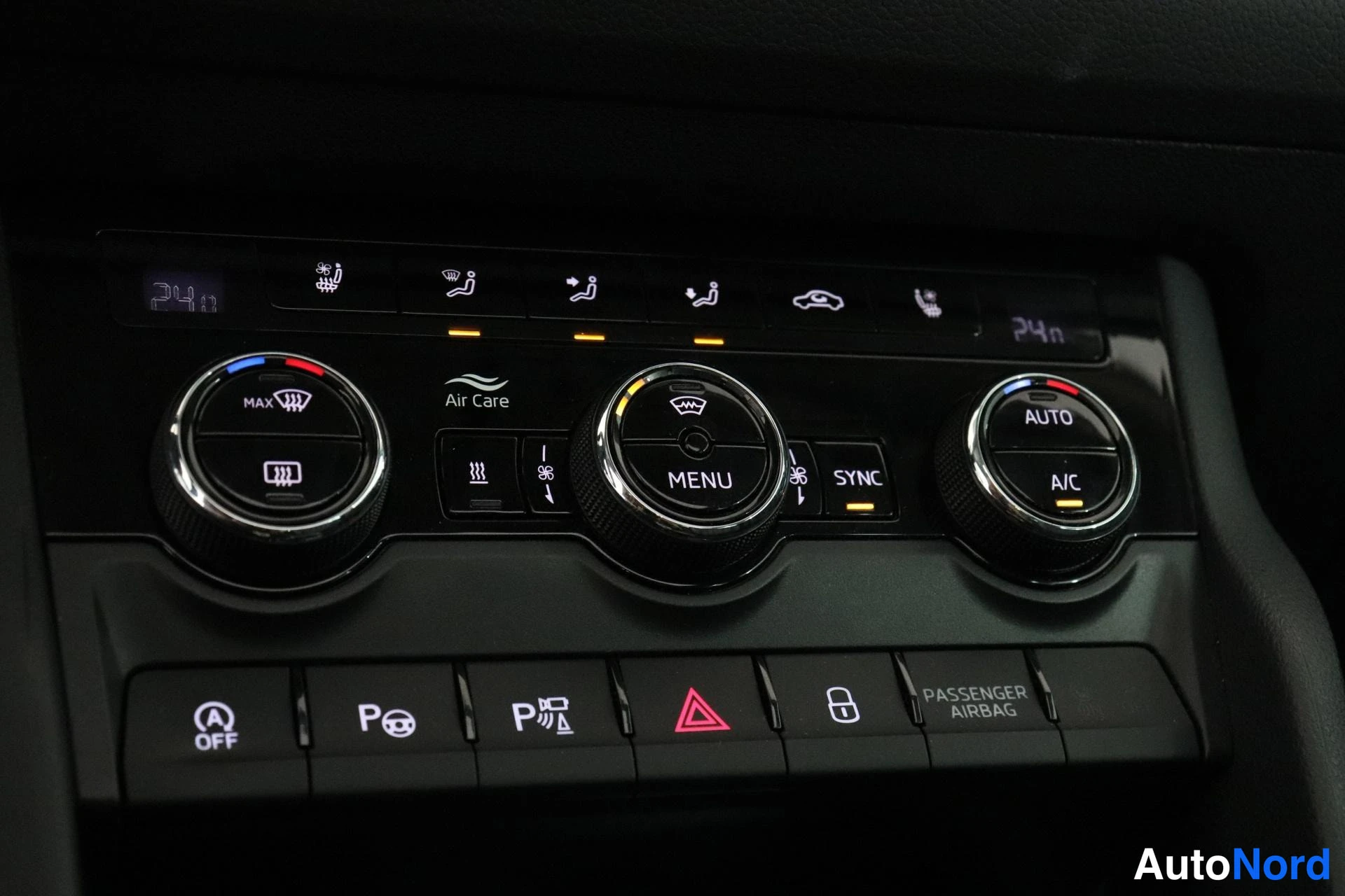 Muu: Auton ilmastointipaneeli pyörökytkimillä, näppäimillä Air Care, AUTO, SYNC, A/C, MAX, P-merkinnöillä ja tekstillä PASSENGER AIRBAG.