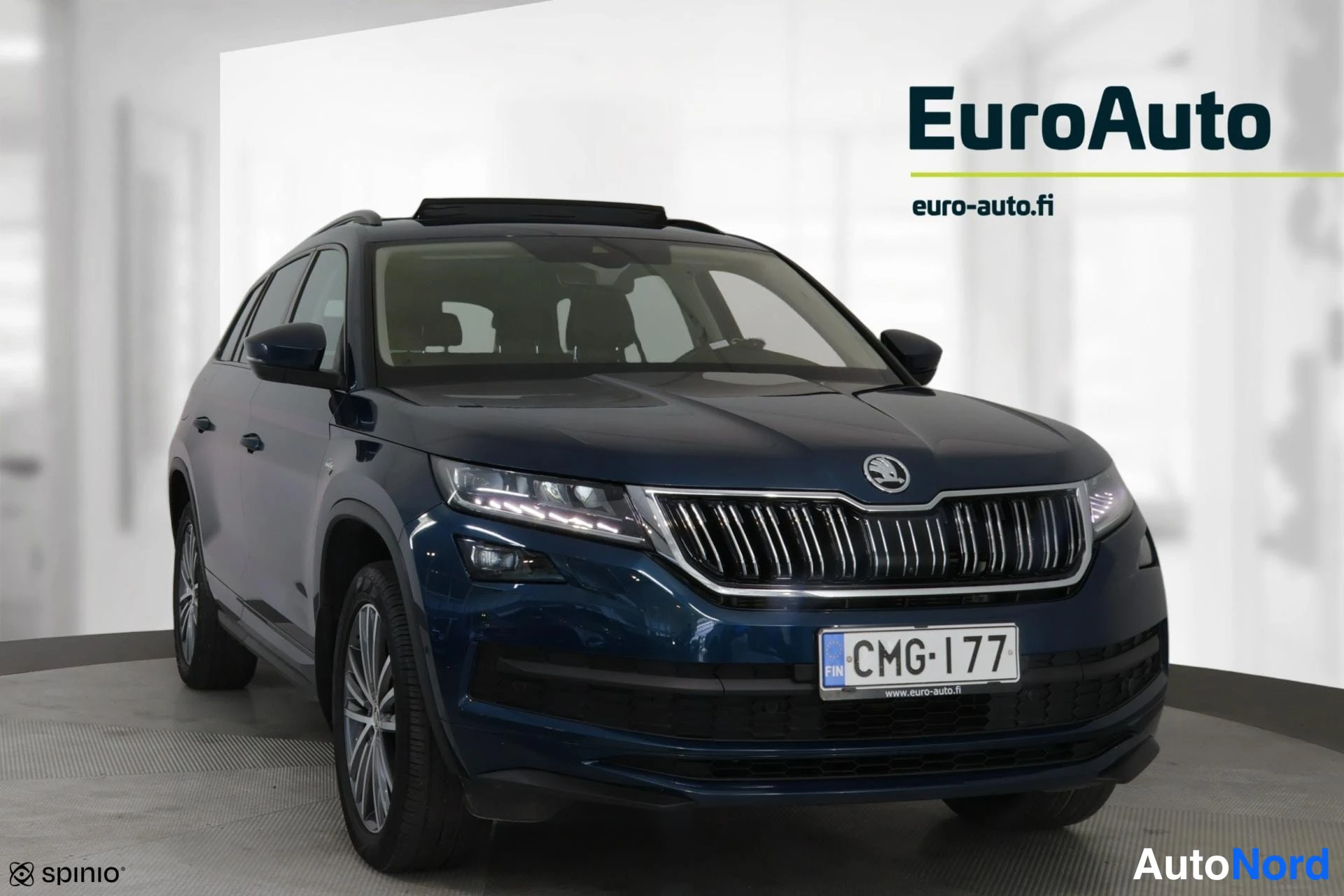 Etuviisto, nokka oikealle: Sininen Skoda Kodiaq -maastoauto kolmasosan kuvakulmasta, keulakuva oikealle osoittaen, rekisteri.
