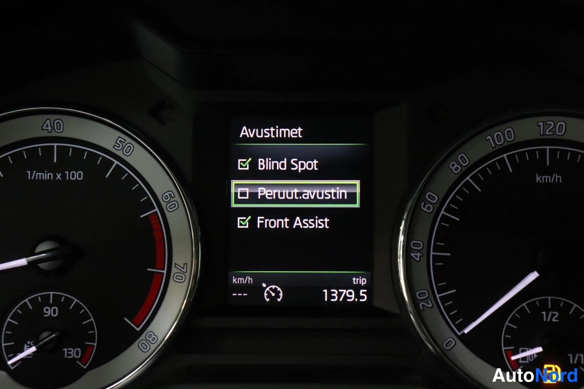 Yksityiskohta: Mittariston Avustimet-valikko: Blind Spot ja Front Assist valittuna, Peruut.avustin valitsematta; trippilaskuri 1379,5 km.