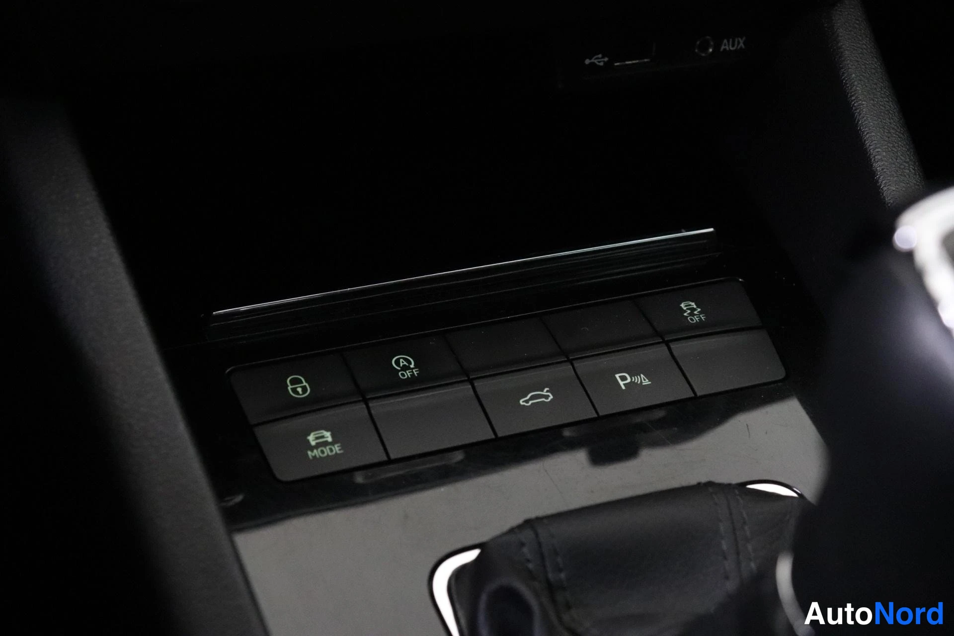 Yksityiskohta: Keskikonsolin alaosa: kytkinpaneli jossa ON/OFF-näppäimistöön kuulumaton Auto Start -Stop Off -painike, lukittumisen eston OFF-painike, takavalot ja parkkimitta