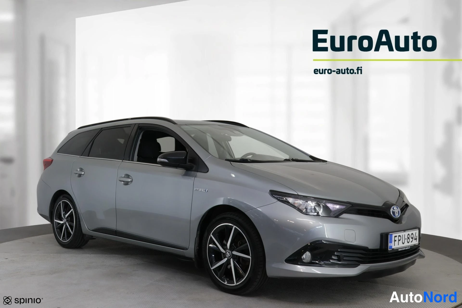 Etuviisto, nokka oikealle: Harmaa Toyota-farmari kolmeneljännäkuvassa keula oikealla, rekisteritunnus.