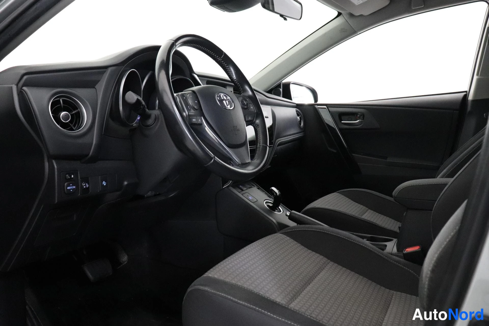 Edestä: Toyota-ratti, kojelauta, vaihteenvalitsin ja kaksi etuistuinta.