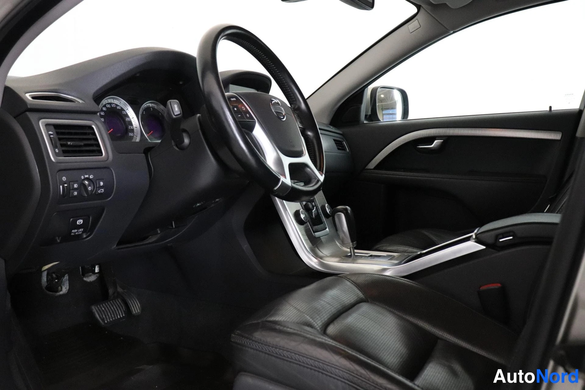 Etuistuimet: Interior view of a car with black leather seats and silver trim on center console