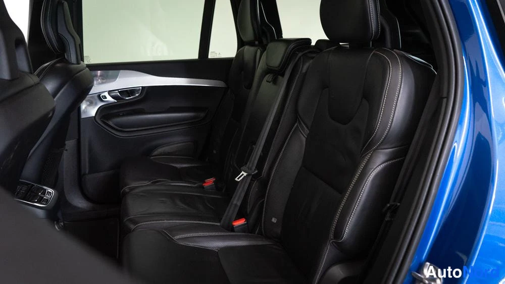 Takaistuimet: Rear interior view showing two black leather rear seats with white contrast stitching through an open right-side door.