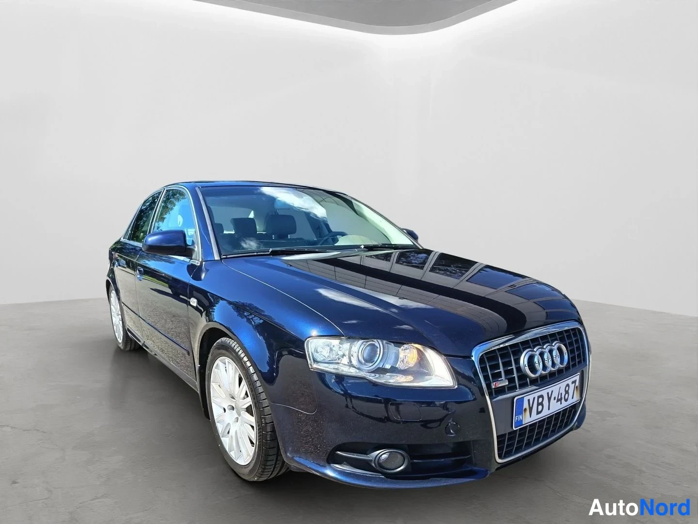 Etuviisto, nokka oikealle: Front three-quarter view of a dark blue Audi sedan.