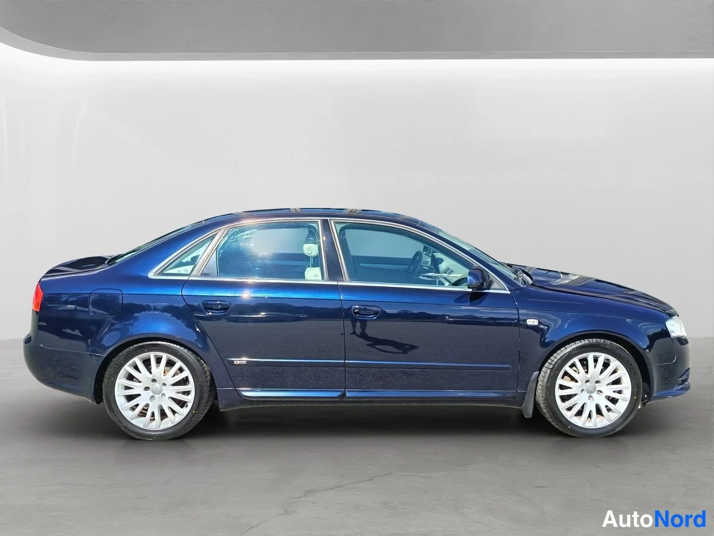 Sivulta: Side view of a dark blue four-door sedan.
