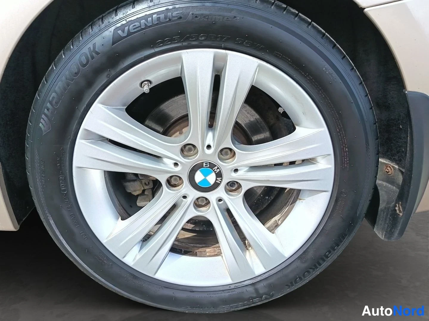 Sivulta: Yksityiskohta BMW:n etupyörästä: hopea lisävarustevanne ja Hankook Ventus Prime2 -rengasyhdistelmä.
