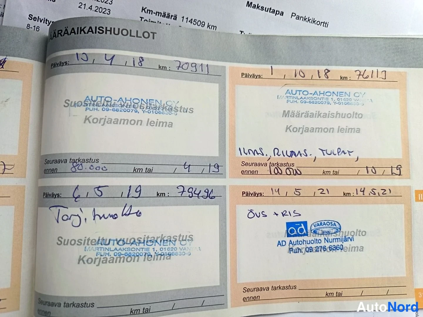 Asiakirja: Palveluohjelman sivu näkyvissä. Nelikkoja täytettyjä tietoja kuten päivämäärät ja kilometrilukemat. Logot AUTO-AHONEN OY, ÖVS+RIS ja AD VARAOSA. Tekstikentissä