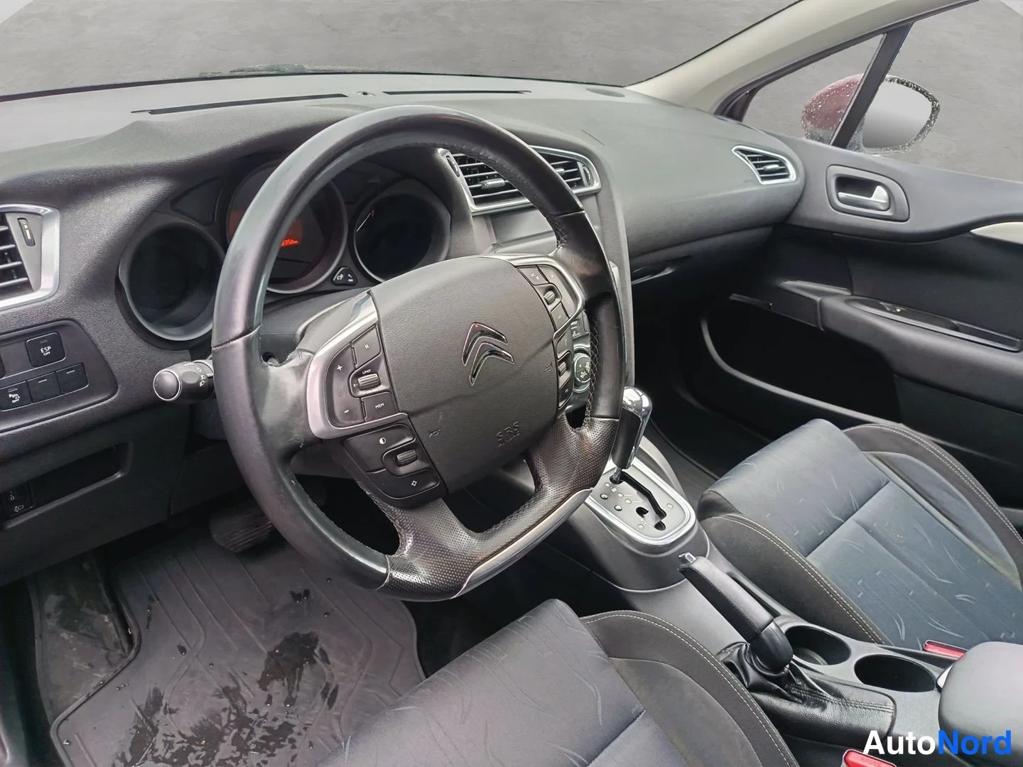 Muu: Auton sisätilat: Citroënin ohjauspyörä ja kojetaulu, automaattivaihteiston valitsin ja etumatkustajan istuin.
