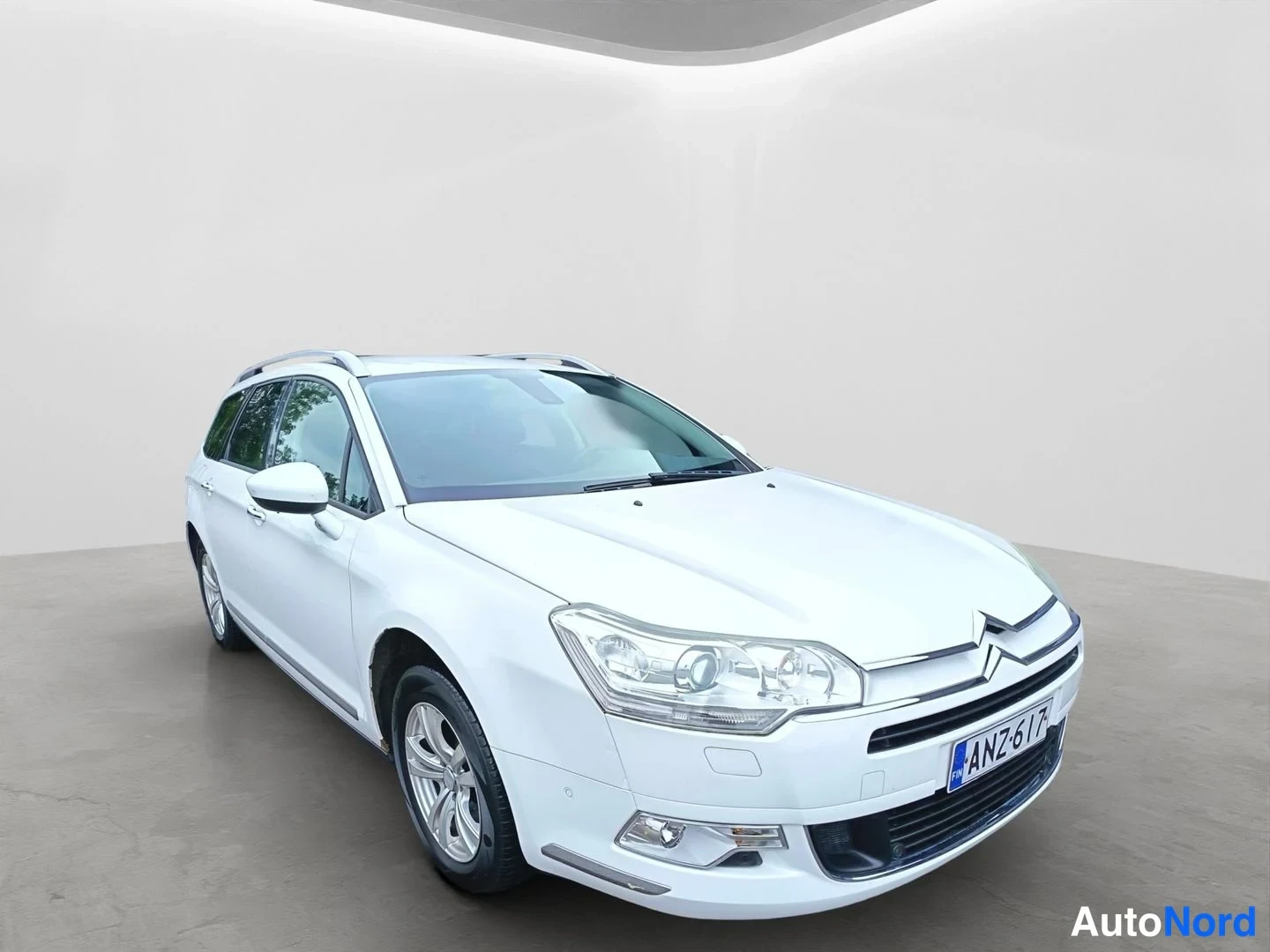 Etuviisto, nokka vasemmalle: A white Citroën C5 Tourer shown from the front three-quarter left angle.