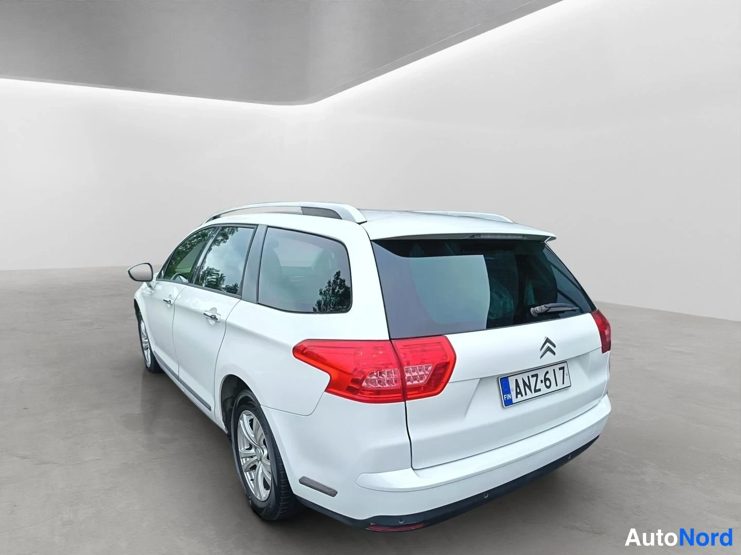 Takaviisto: Valkoinen Citroen C5 Tourer -farmari takaa vasemmalta kuvattuna studiossa, rekisteritunnus.