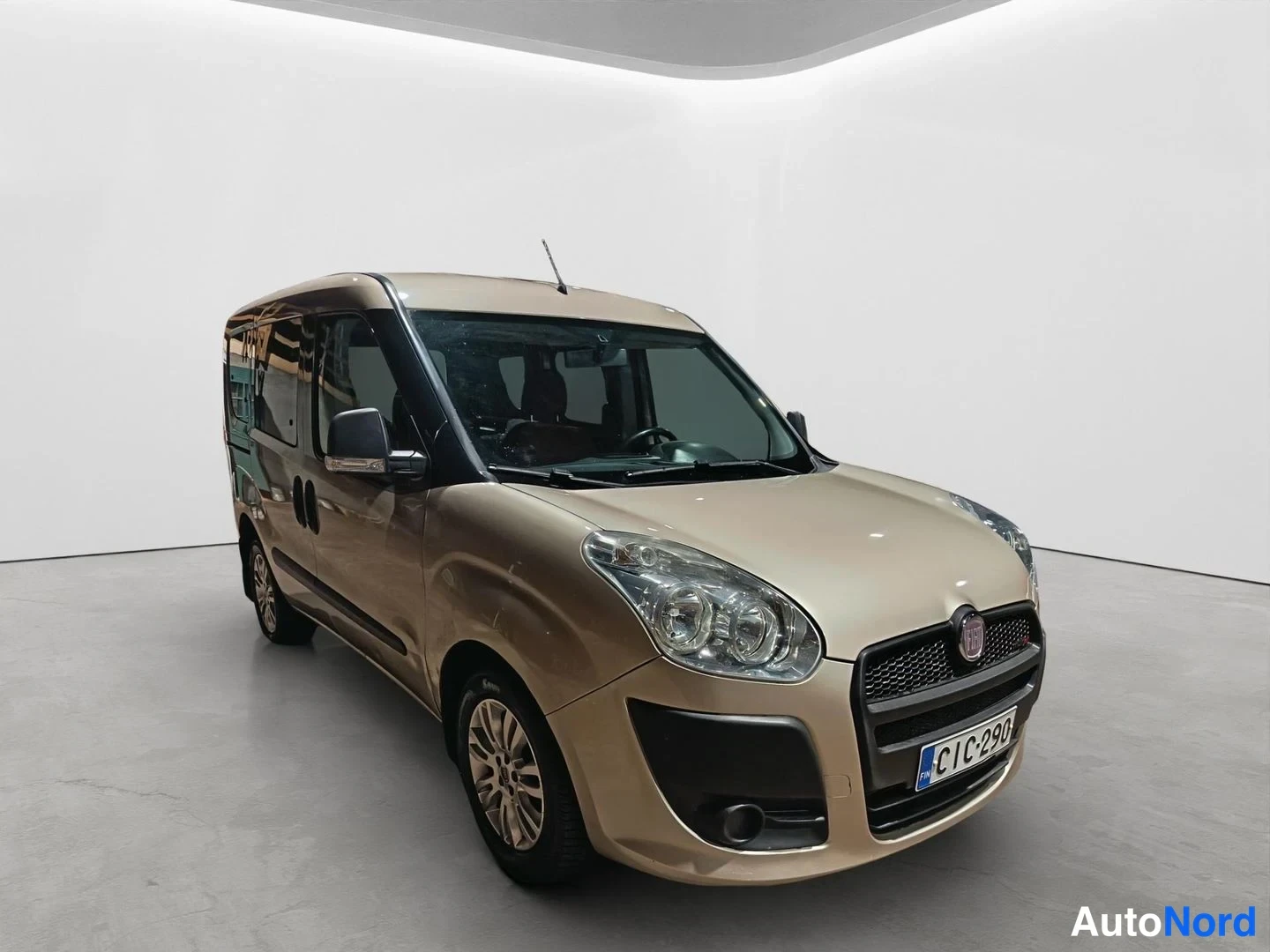 Etuviisto, nokka oikealle: Fiat Doblo etuviistöstä oikealta, vaalean beige, rekisteri, studiovaalea tausta.