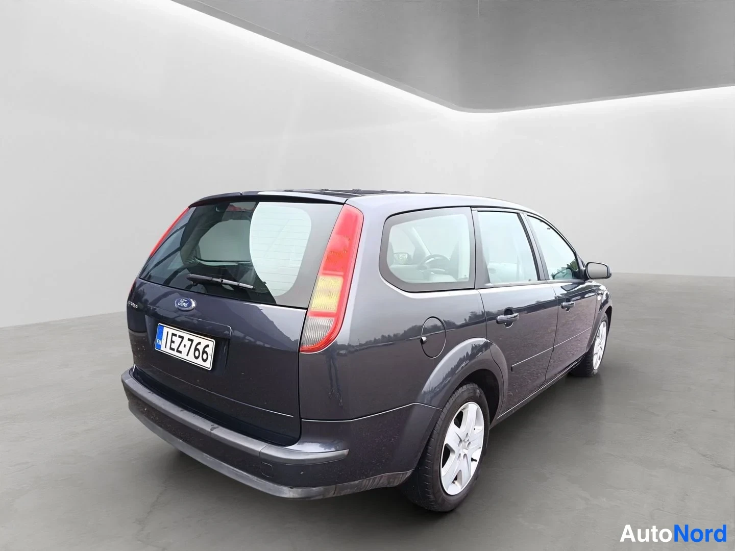 Takaviisto: Ford Focus Farmari takaviisto vasemmalta, tummanharmaa kori, rekisterikilpi.