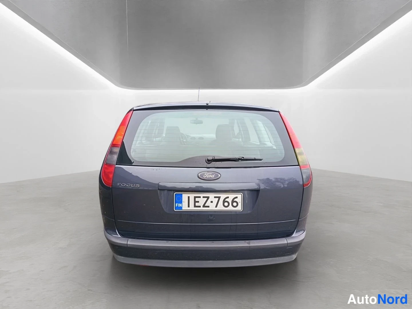 Takaa: Ford Focus Farmari suoraan takaa, tummanharmaa kori, Focus-teksti ja rekisterikilpi.