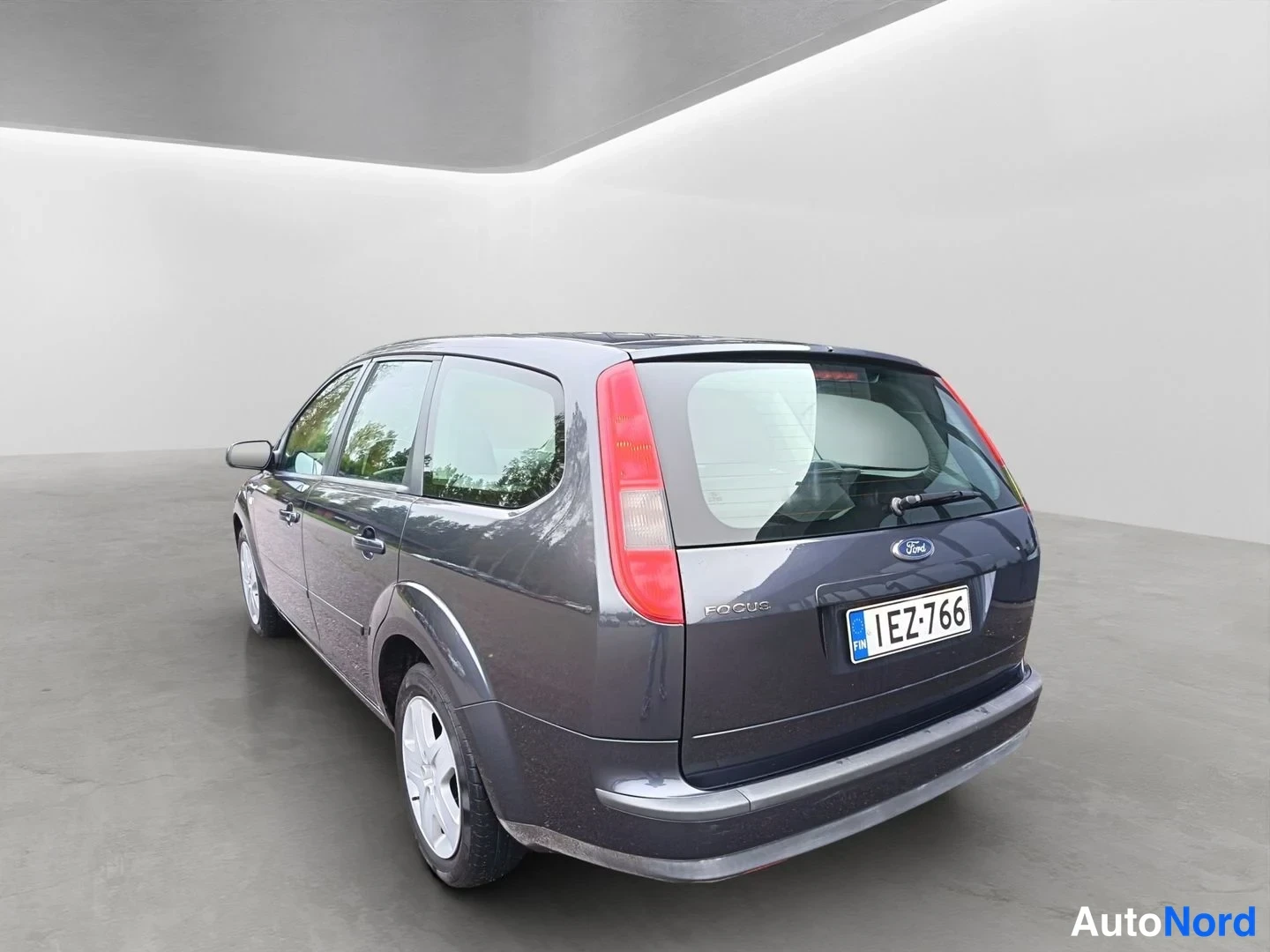 Takaviisto: Ford Focus Farmari takaviisto oikealta, tummanharmaa kori, rekisterikilpi.