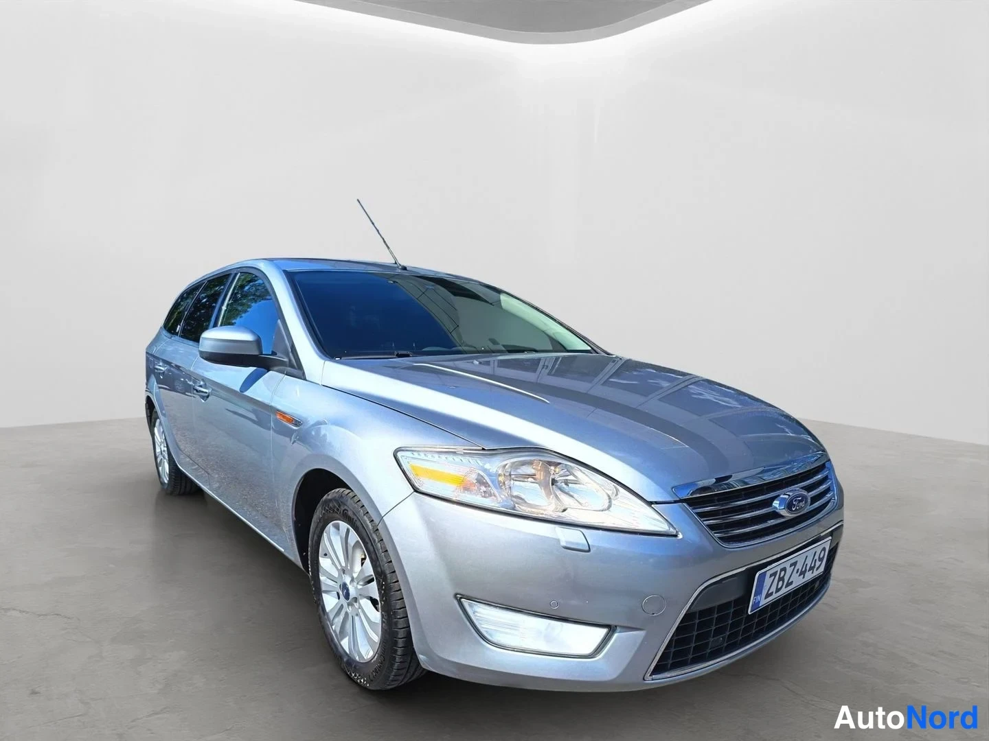 Etuviisto, nokka oikealle: Hopeanvärinen Ford Mondeo Farmari kuvattuna kolmannesvinkkelistä, keula oikealla ja vasen kylki näkyvissä.