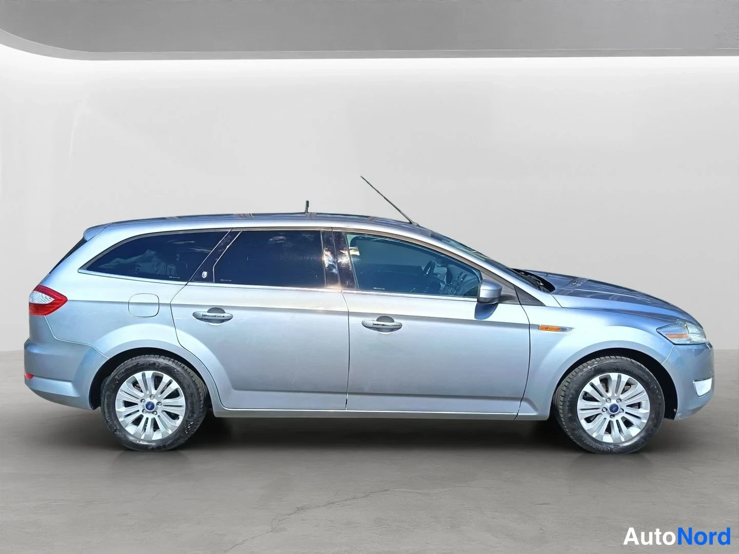 Sivulta: Hopeanvärisen Ford Mondeo Famarin vasen sivuprofiili sisätiloissa.