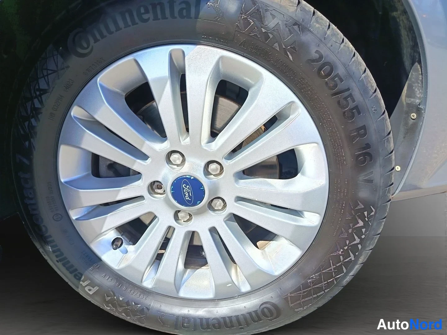 Yksityiskohta: Auton alkuvanteen ja renkaan lähikuva. Renkaan sivussa lukee Continental ja 205/55 R 16 V.