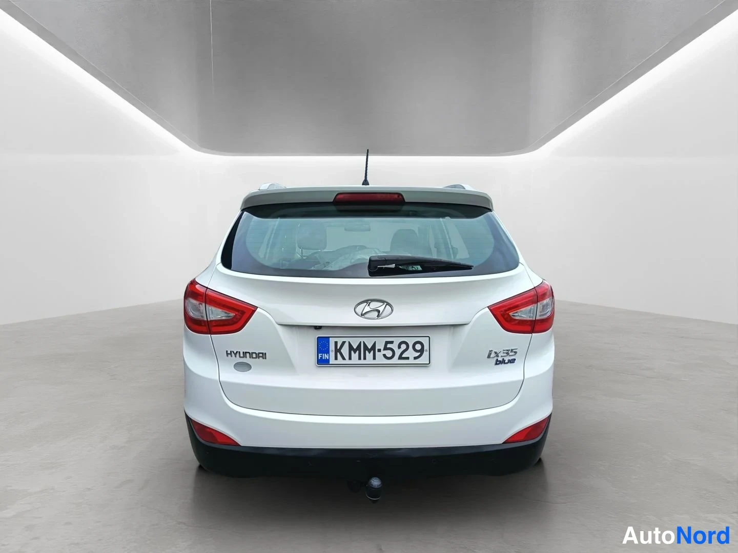 Takaa: Hyundai ix35:n suora takakuva: valkoinen korinväri, punaiset takavalot, -rekisterikilpi, Hyundai- ja ix35 blue -tekstit.