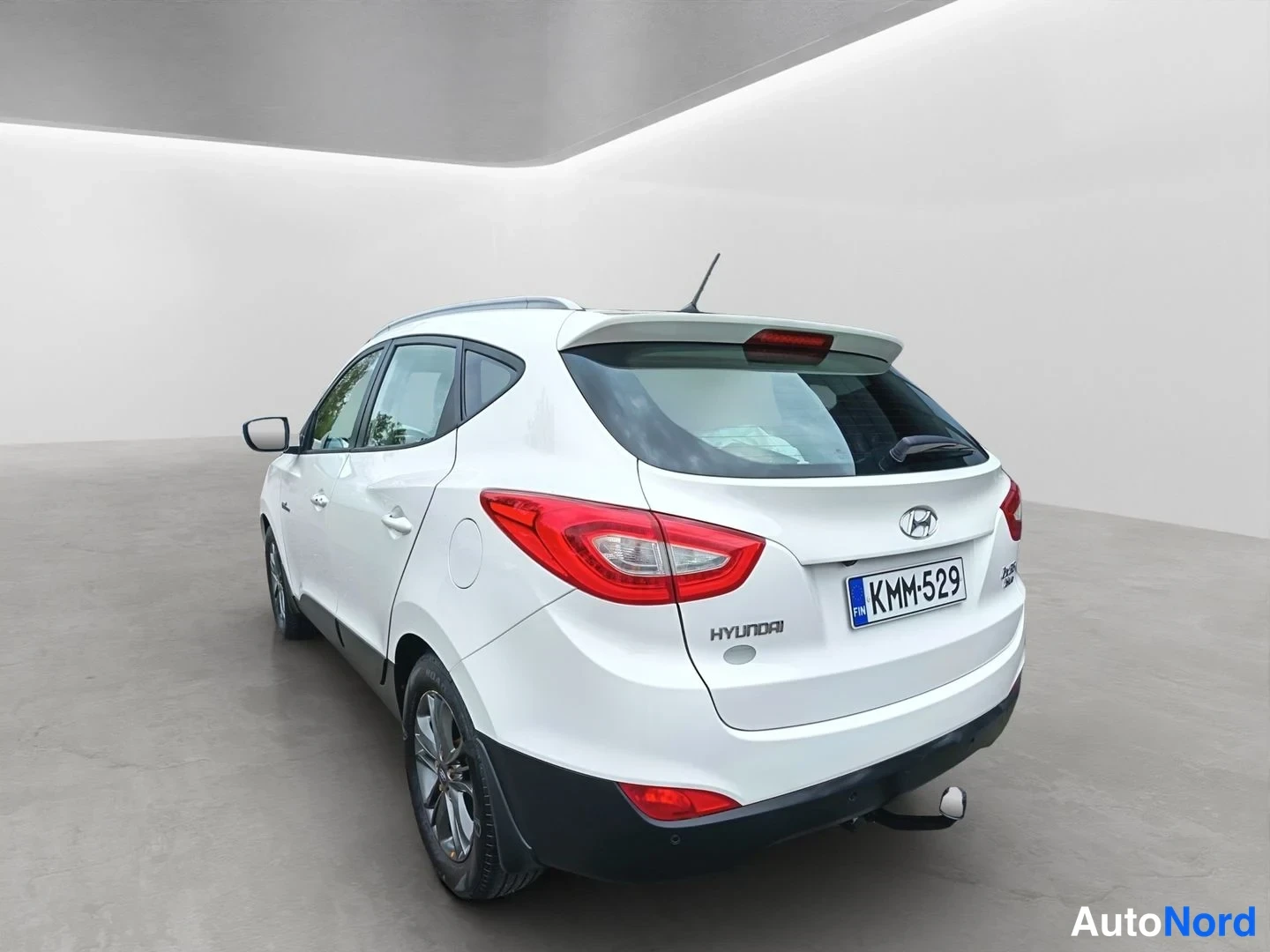 Takaviisto: Hyundai ix35:n takakulmasta oikealta kuvattu kuva: valkoinen korinväri, punaiset takavalot, -rekisterikilpi ja vetoautojenostokoulu.