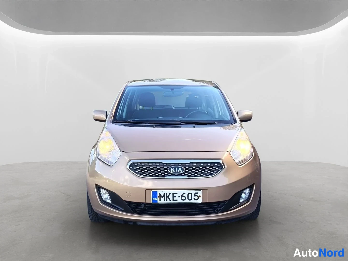 Edestä: Kia Venga -henkilöauto suoraan edestä kuvattuna, etusäleikkö ja KIA-merkki näkyvissä, rekisteritunnus.