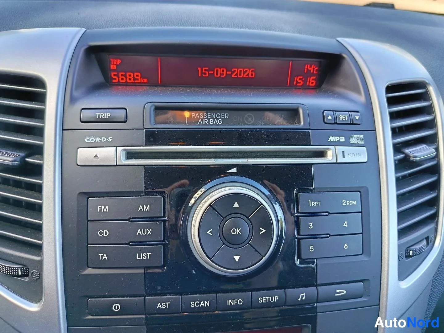 Muu: Kojelaudan radiopaneeli CD/AUX- ja MP3-merkinnöin, näytössä tripmeter 5689 km, päivämäärä 15-09-2026 ja lämpötila 14°C.