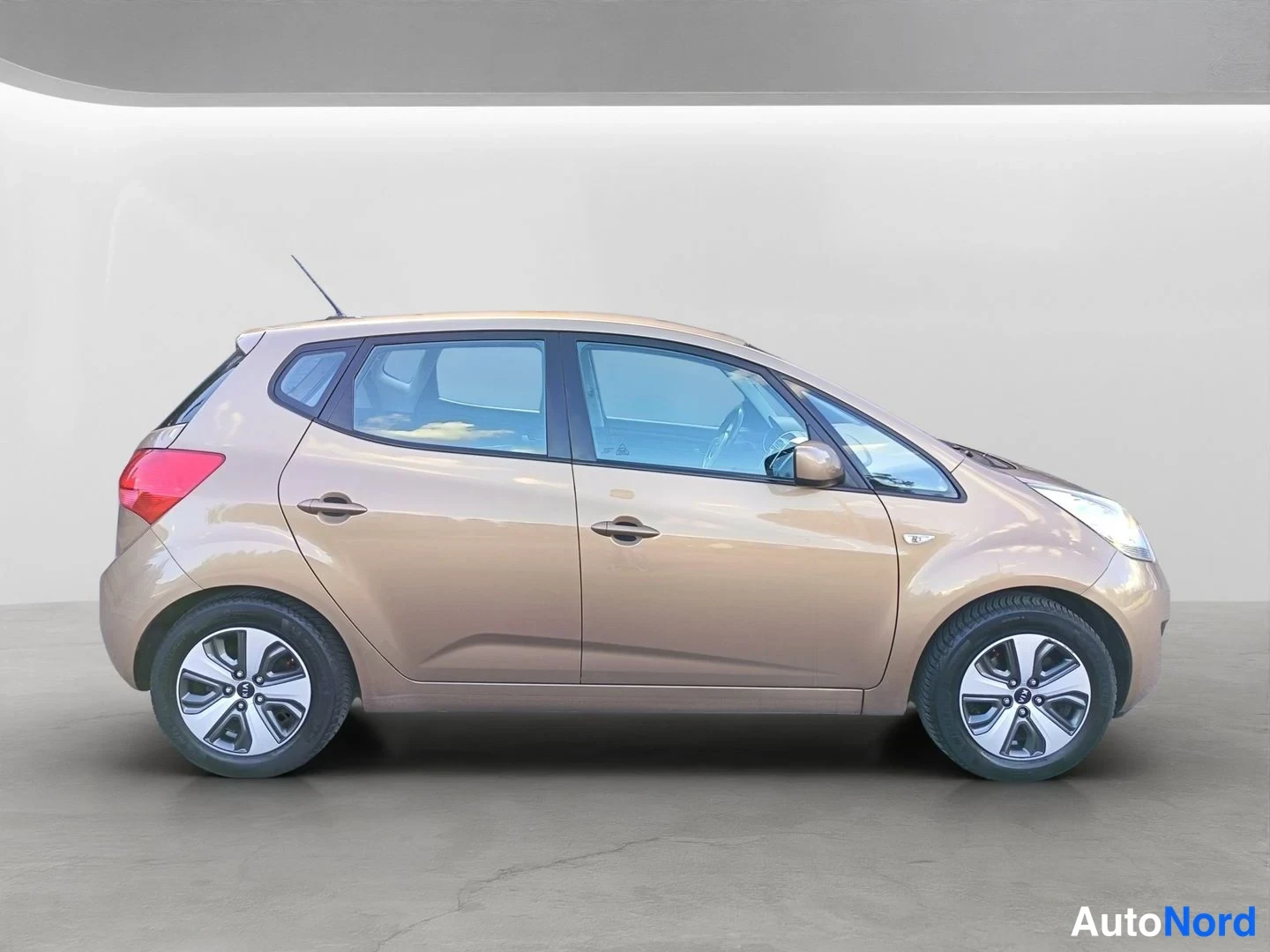 Sivulta: Kia Venga -henkilöauto sivukuva oikealta, viistoperä, vaaleanbeige koriväri, viisi ovea näkyvissä.
