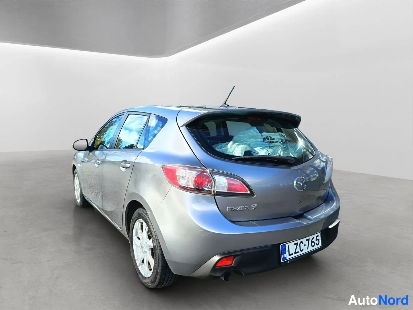 Takaviisto: Mazda 3 -viistotakakulma vasemmalta: takaosa ja vasen kylki näkyvät, rekisteritunnus.