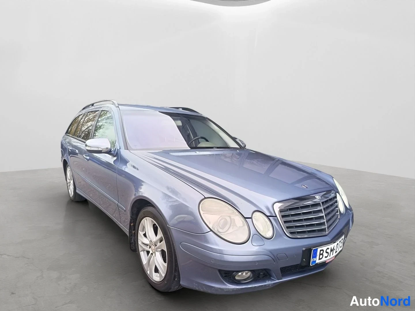 Etuviisto, nokka oikealle: Mercedes-Benz E-sarjan farmari etukanavalta oikealta, sinertävänharmaa