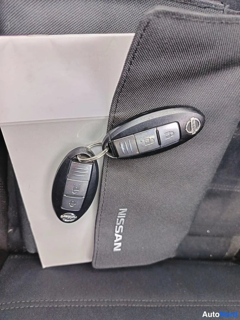 Yksityiskohta: Kaksi Nissan-etäisesti ohjattavaa avainlupaa mustassa Nissan-merkkisessä pussissa.