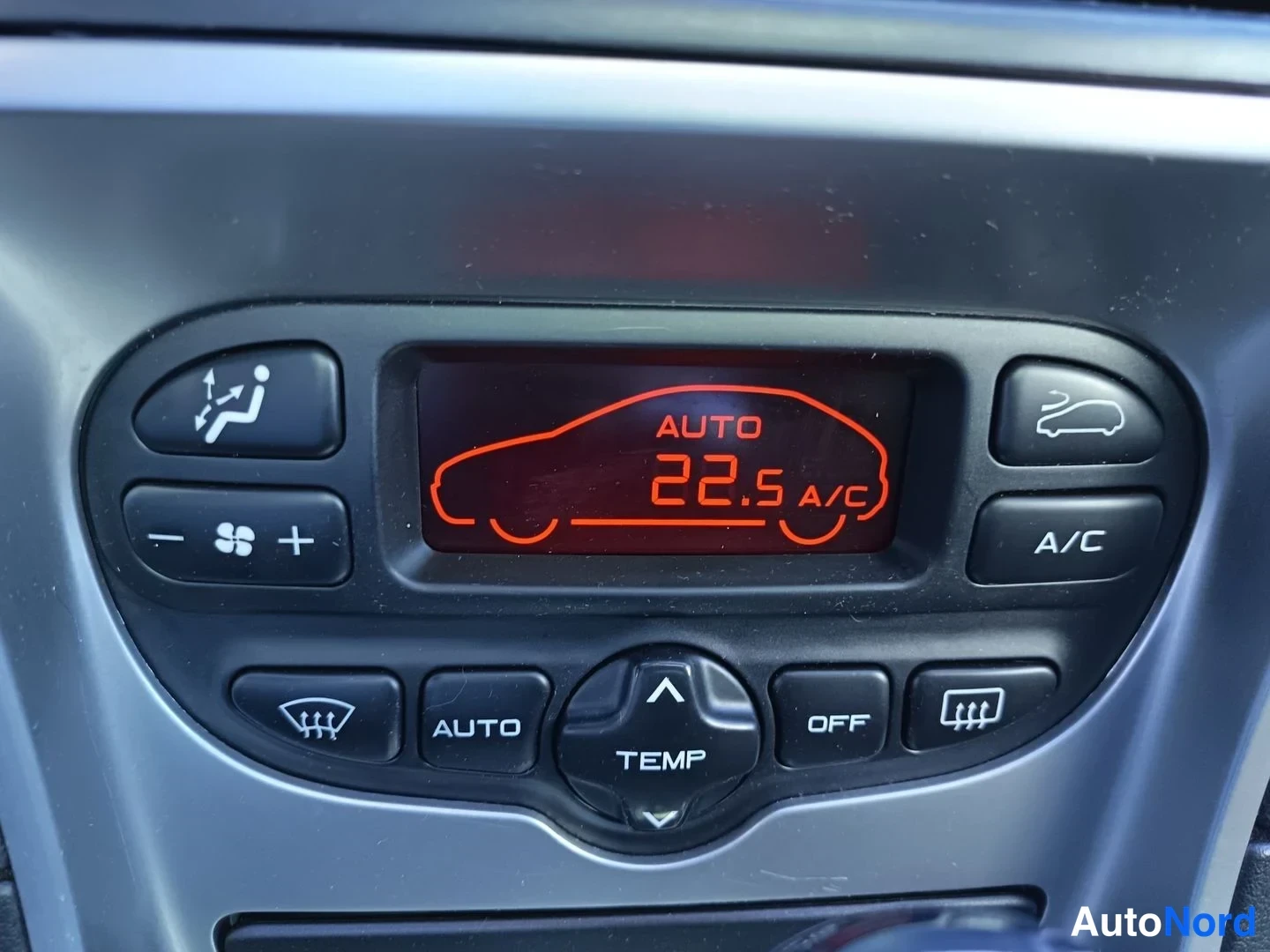 Yksityiskohta: A/C-paneelin merkit: A/C, AUTO, TEMP, OFF ja lämpötilanäyttö 22.5 A/C.