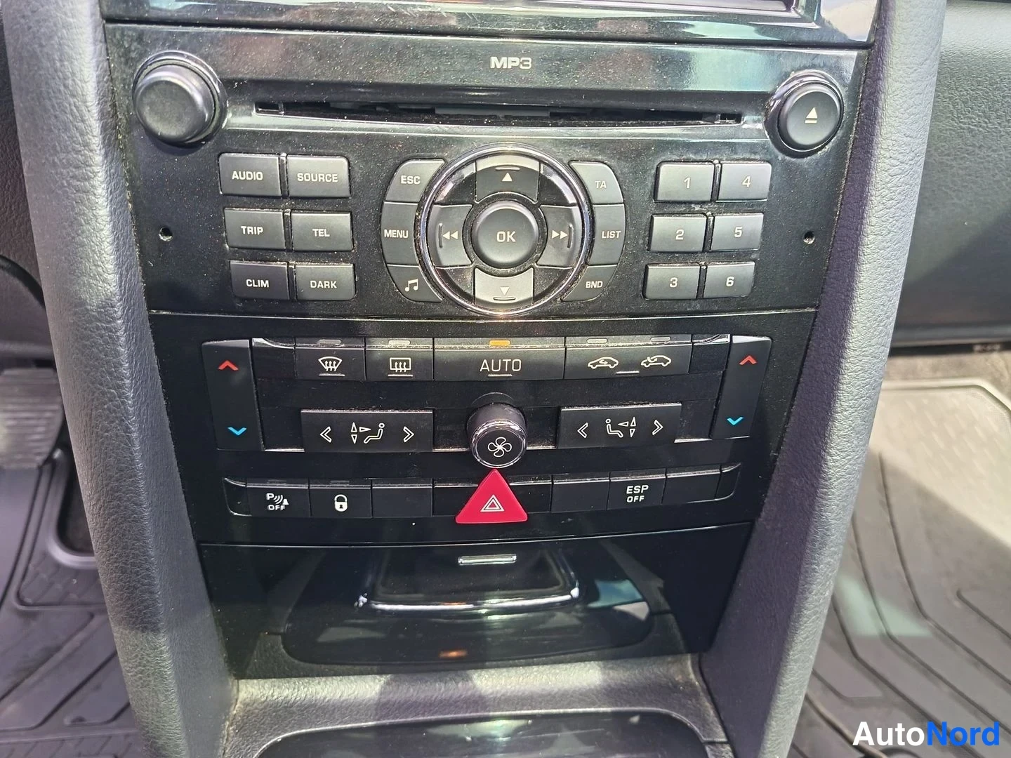 Muu: Kojeiston keskusyksikkö lähikuva: MP3-CD-soitin numeronäppäimilla, automaattinen ilmastointi (AUTO), ESP OFF- ja parkkitutkapainikkeet sekä varoituskolmiopainik