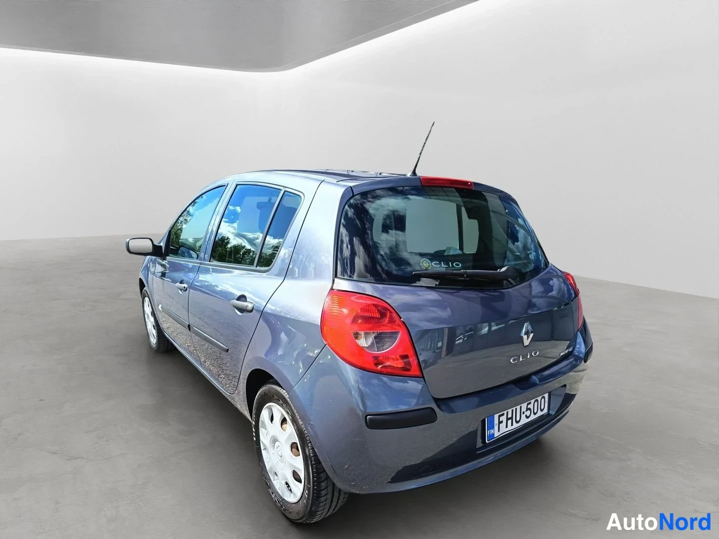 Takaviisto: Renault Clio -viistoperä takaa vasemmalta oikealle kuvattuna, rekisteritunnus, näkyvissä takavalot ja sivupeilit.