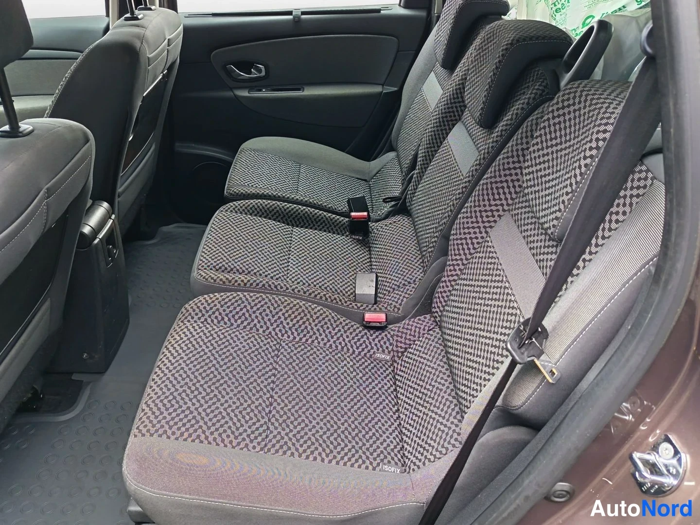 Yksityiskohta: autonsa takapenkki ja kolmannen rivin istuimet kuosikankaalla; ISOFIX-merkinnät penkeissä, kolmen pisteen hihnat, tumma kumimatto lattialla.