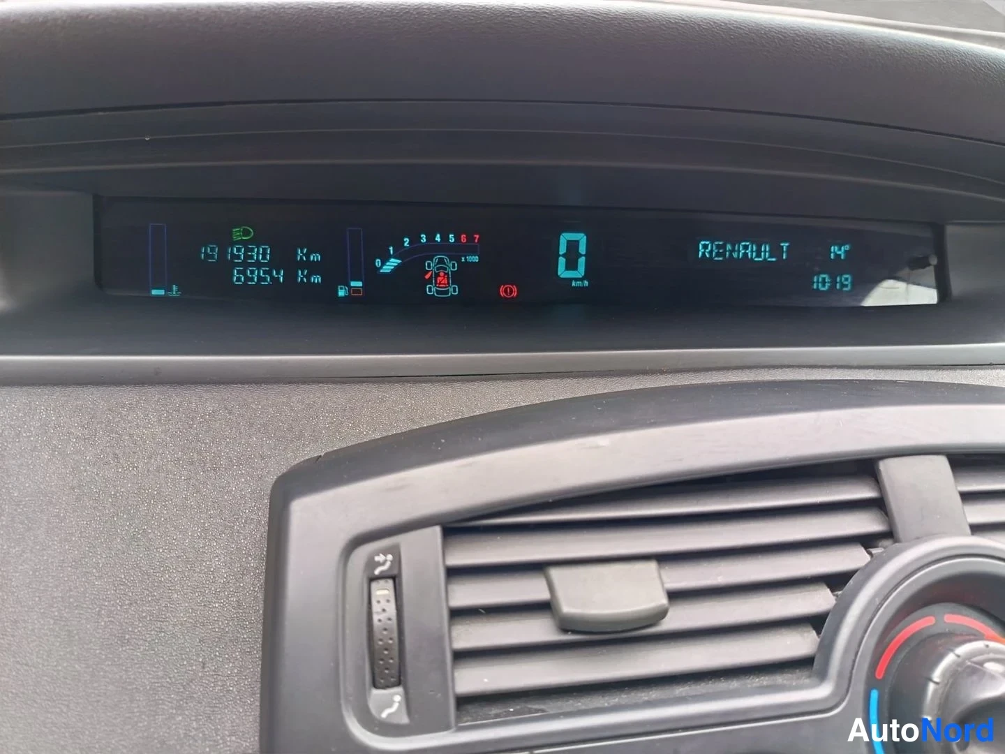 Muu: Renaultin mittariston ylä- ja alaosa lähikuvassa. Digitaalinäytössä lukemat 191930 km ja 6954 km, nopeus 0 km/h sekä teksti RENAULT, kellonaika 10:19 ja lämpöti