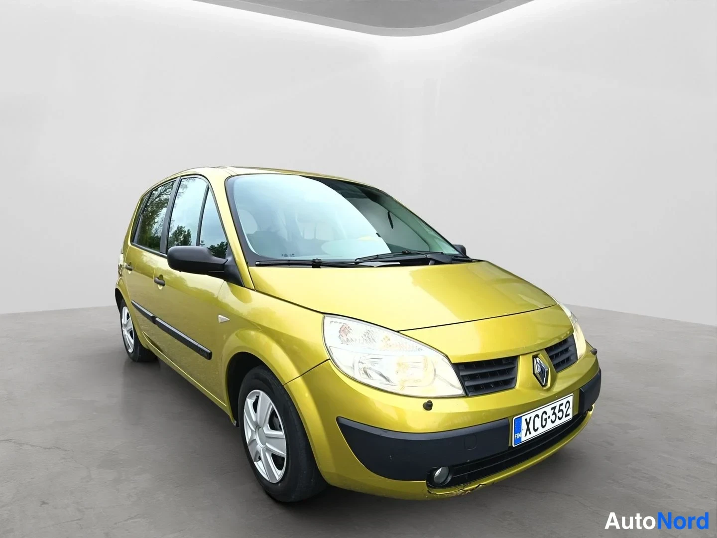 Etuviisto, nokka oikealle: Renault Scenic -henkilöauto keltainen, etunurkku kuvattuna oikealta