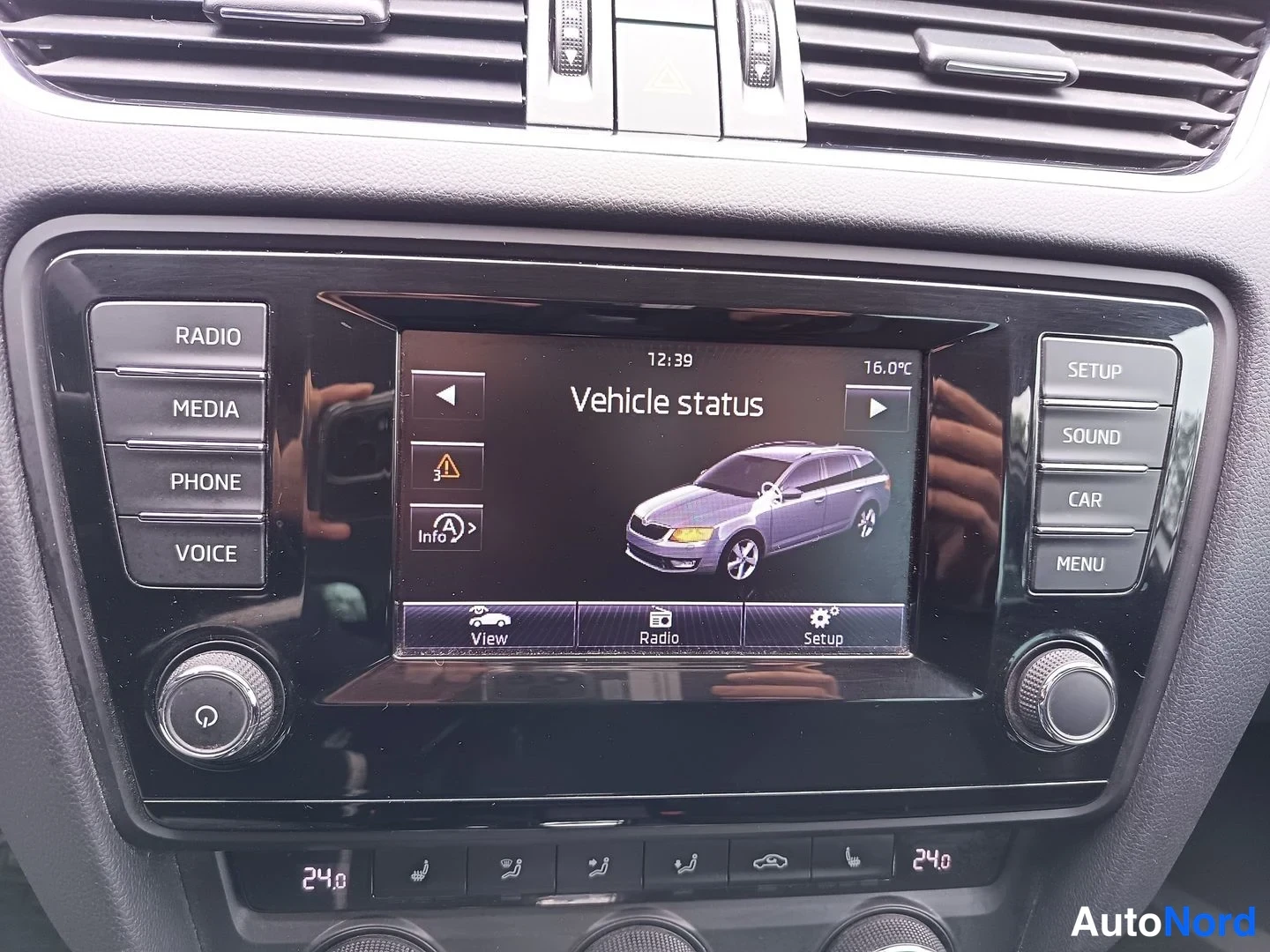 Muu: Keskiössä infotainment-näyttö Vehicle status -näkymässä; RADIO-, MEDIA-, PHONE- ja VOICE-painikkeet sekä kaksivyöhykeilmastointipaneeli näkyvät.