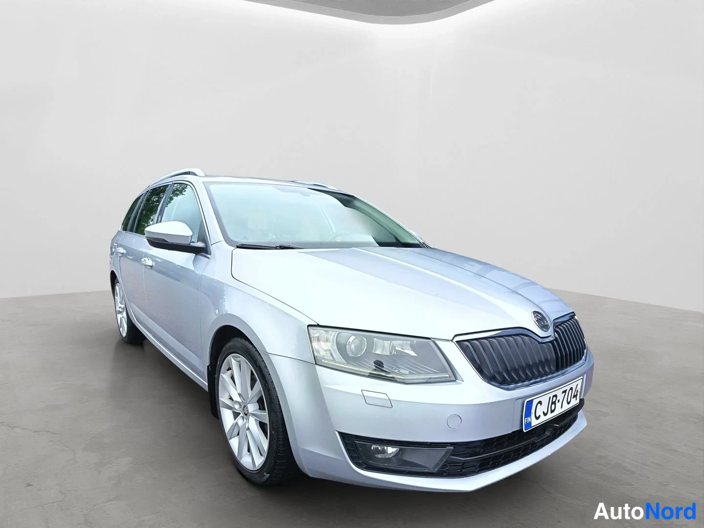 Etuviisto, nokka oikealle: Hopeinen Skoda Octavia -farmari kuvattuna etuviistosta studiossa; etusäleikkö, ajovalot ja rekisterikilpi näkyvät.