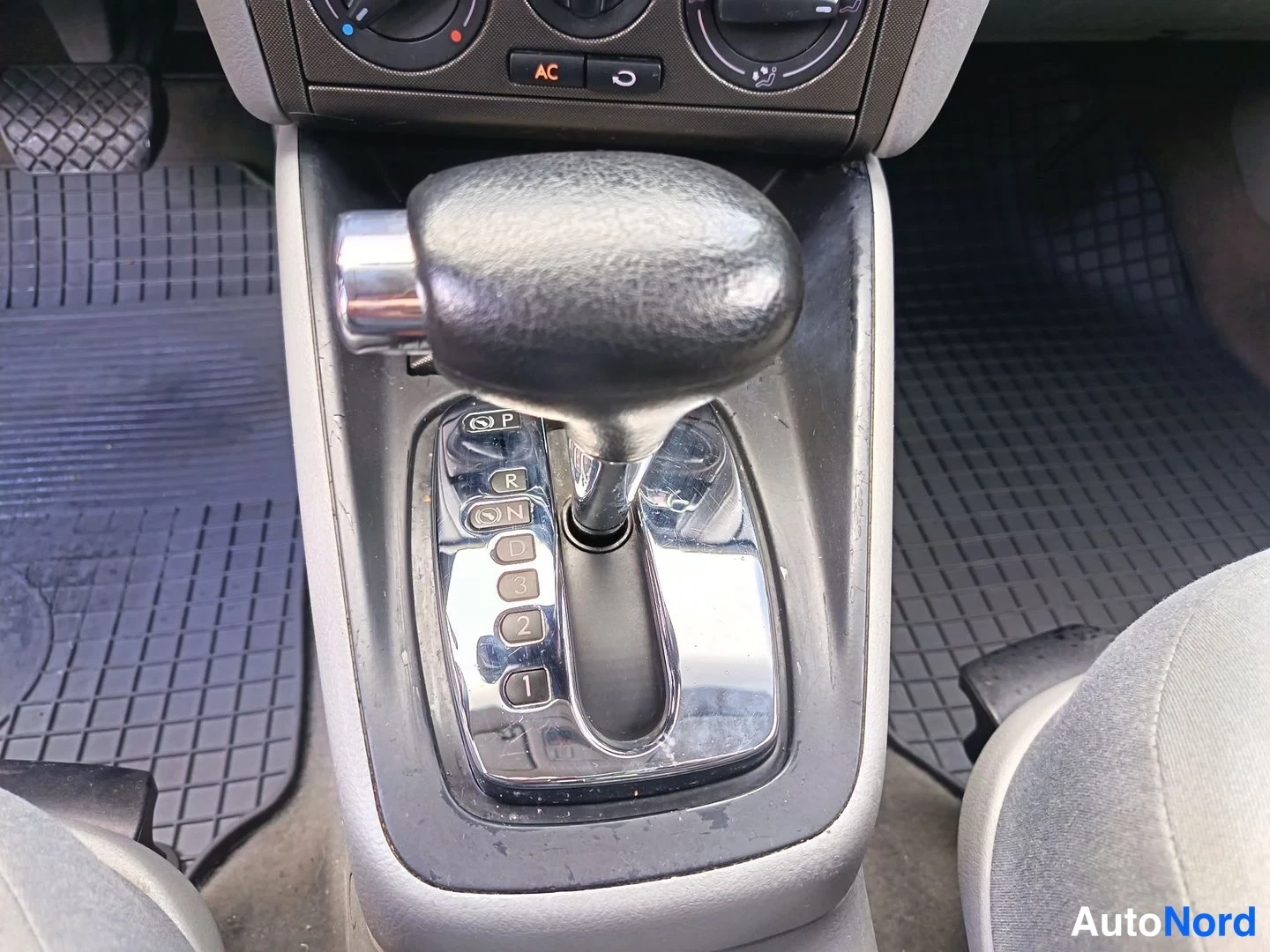 Ohjaamo: Automatic gear selector lever in the center console area. The shift pattern plate shows Park (P), Reverse (R), Neutral (N), Drive (D) and manual gate (3-2-1). G