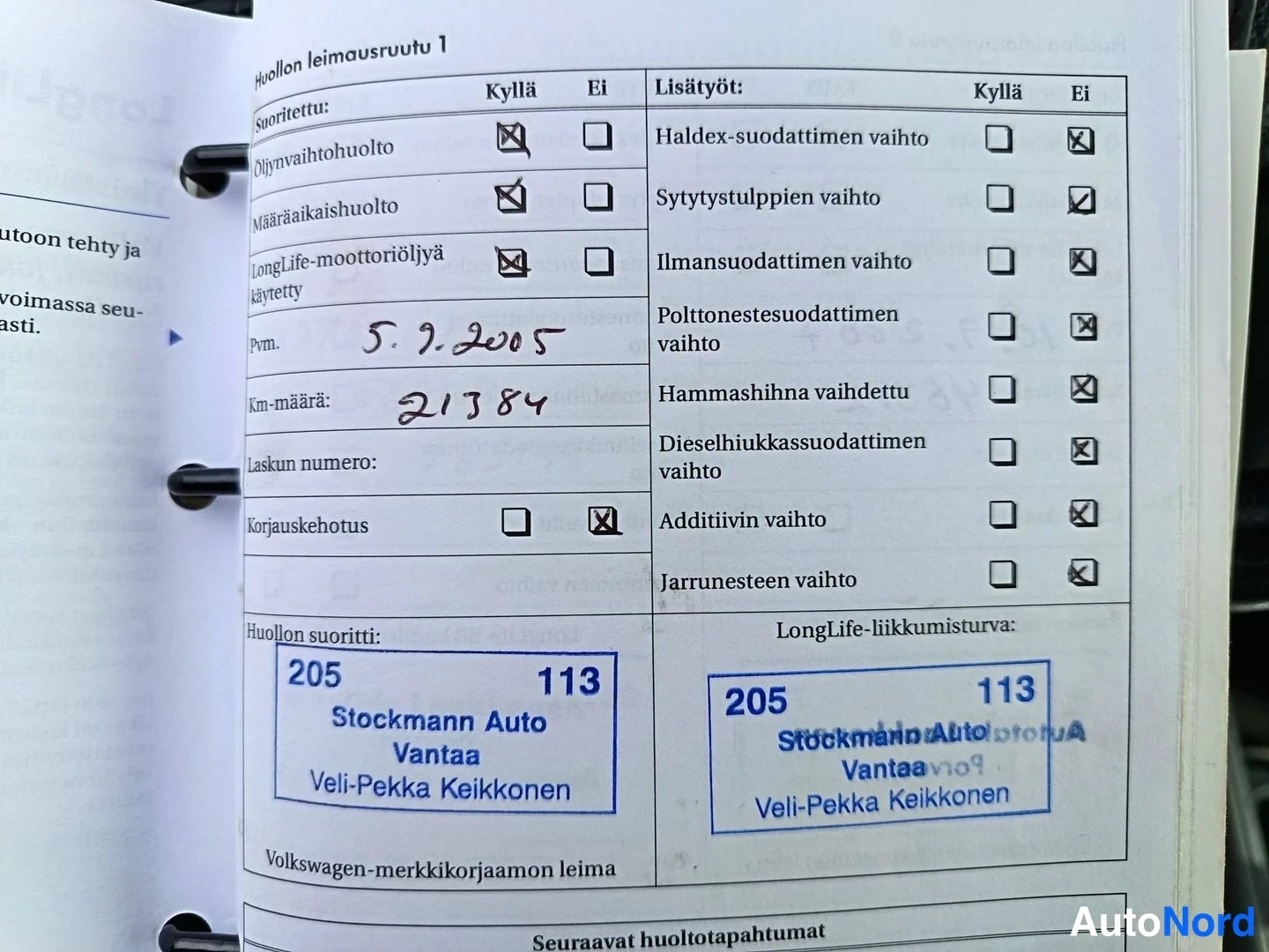 Asiakirja: Kuva autopalvelukirjan huoltokortista. Kirja on avoinna näyttäen sivut 'Huollon leimausruutu 1' ja siihen liittyvät tiedot.