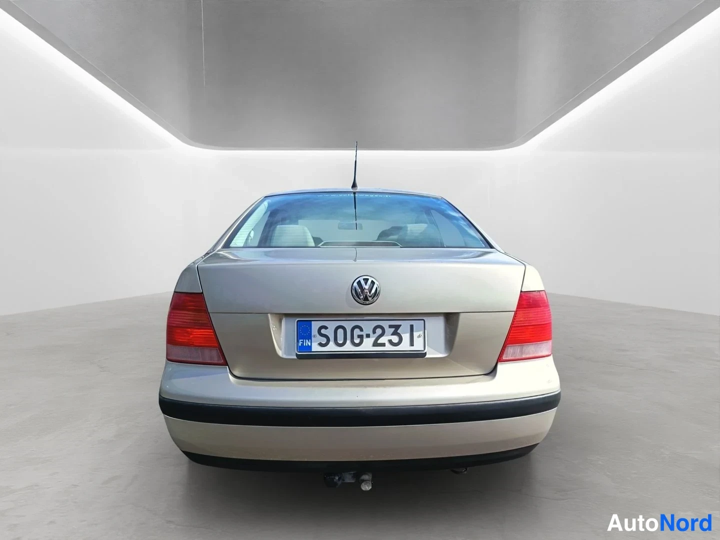 Takaa: A head-on view of the rear face of a beige VW sedan. A tow hitch is fitted below the bumper, and the Finnish license plate reads.