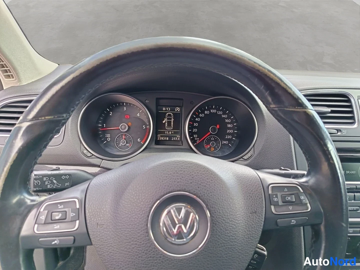 Muu: Kuljettajan näkymä Volkswagen-ohjauspyörän läpi mittaristoon: nopeusmittari, kierrosmittari ja näyttö, jossa lukema 239318 km.