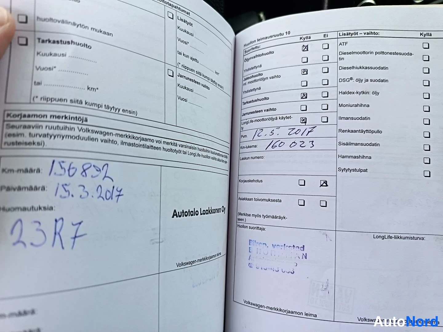 Asiakirja: Two-page spread from a vehicle service booklet. Left page shows dated entry 15.3.2017 with odometer reading 156892 km. Right page shows another service record d