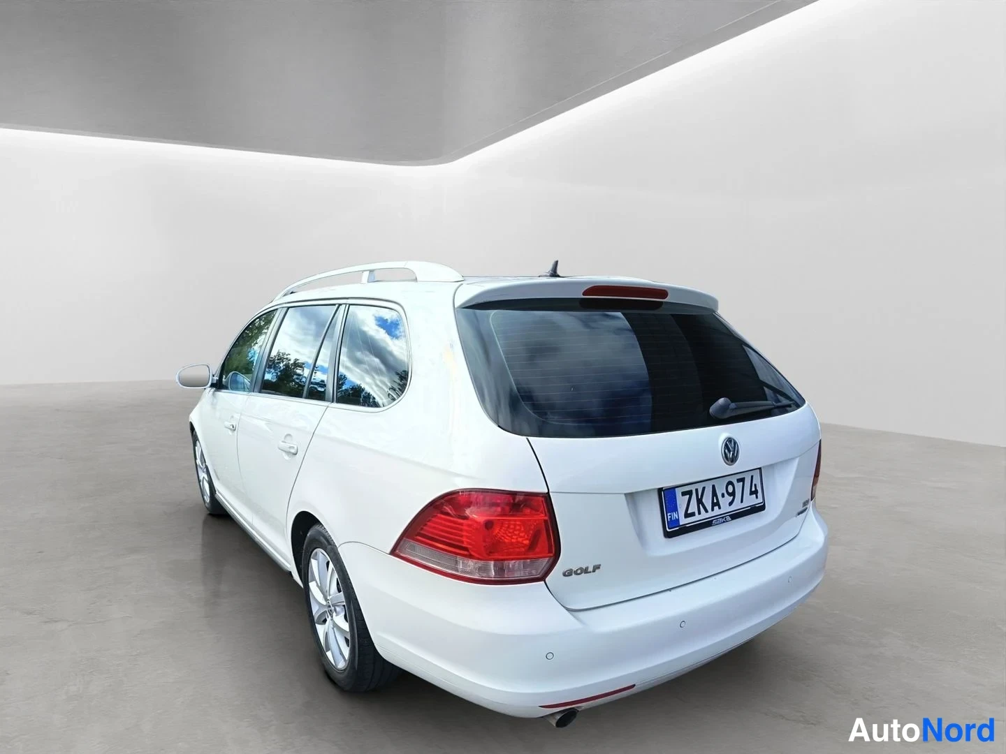 Takaviisto: The car is photographed from the left rear quarter. The left flank, the rear window, and the taillight are visible. White roof rails run across the roof.