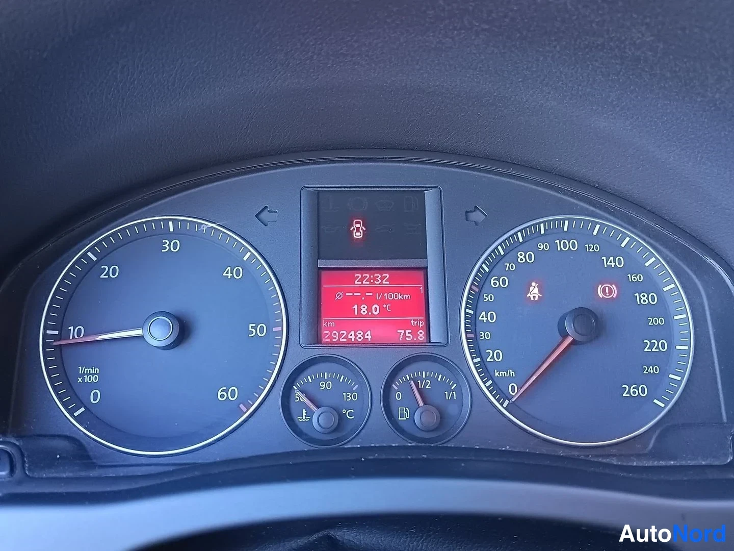 Ohjaamo: Instrument panel showing analogue dials: tachometer left, speedometer right, central digital display with red backlight reading 292484 km. Warning lights visibl