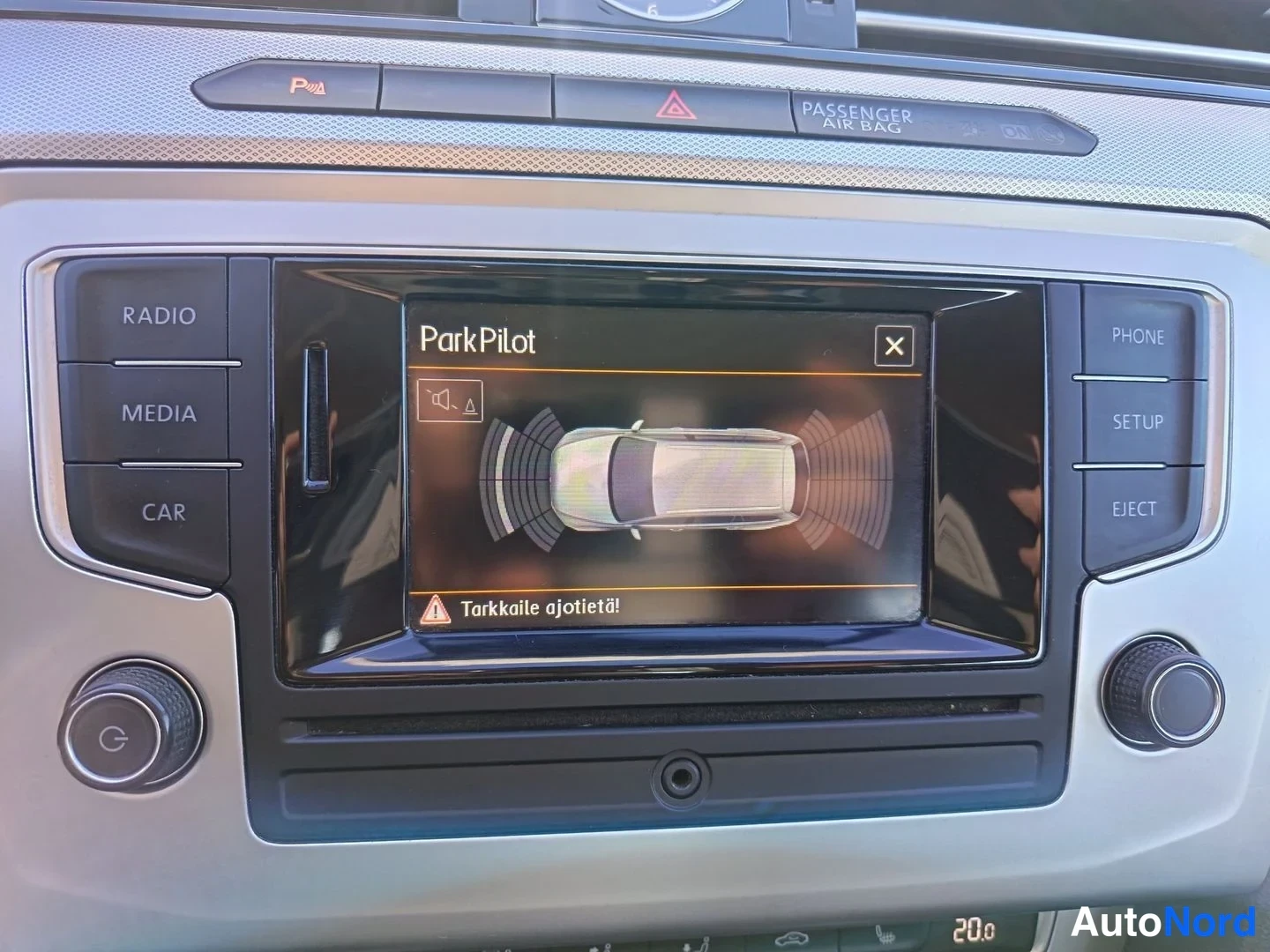 Etuviisto: Keskikonsolin infotainment-näyttö näyttää ParkPilot-tutkatiedot autonkuvan ympärillä; sivuilla RADIO-, MEDIA-, CAR-, PHONE-, SETUP- ja EJECT-painikkeet.