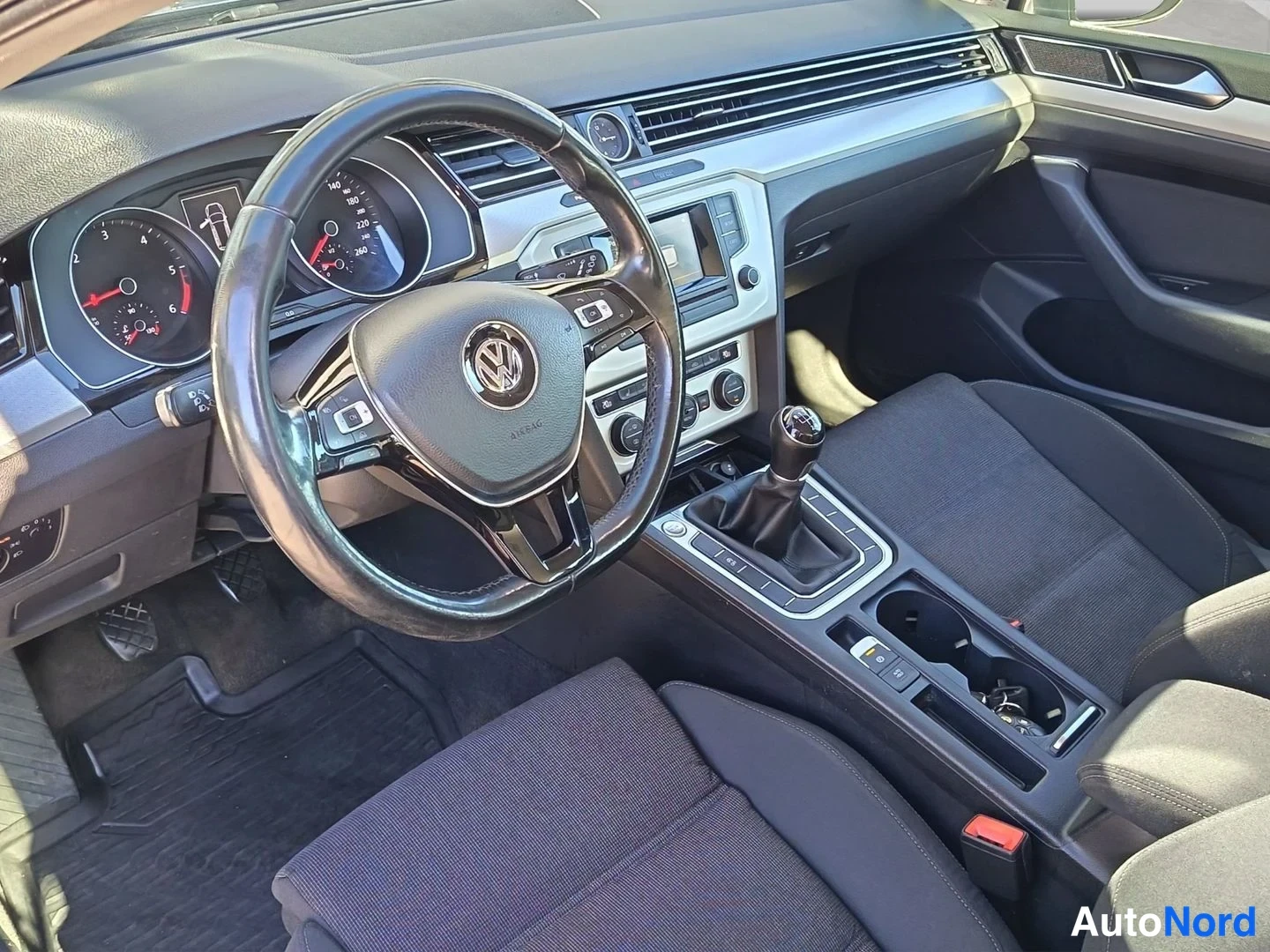 Muu: Ohjaamo vasemmalta katsottuna: VW-ohjauspyörä, analogiset mittarit, manuaalivaihtoheitin ja tummat penkit.