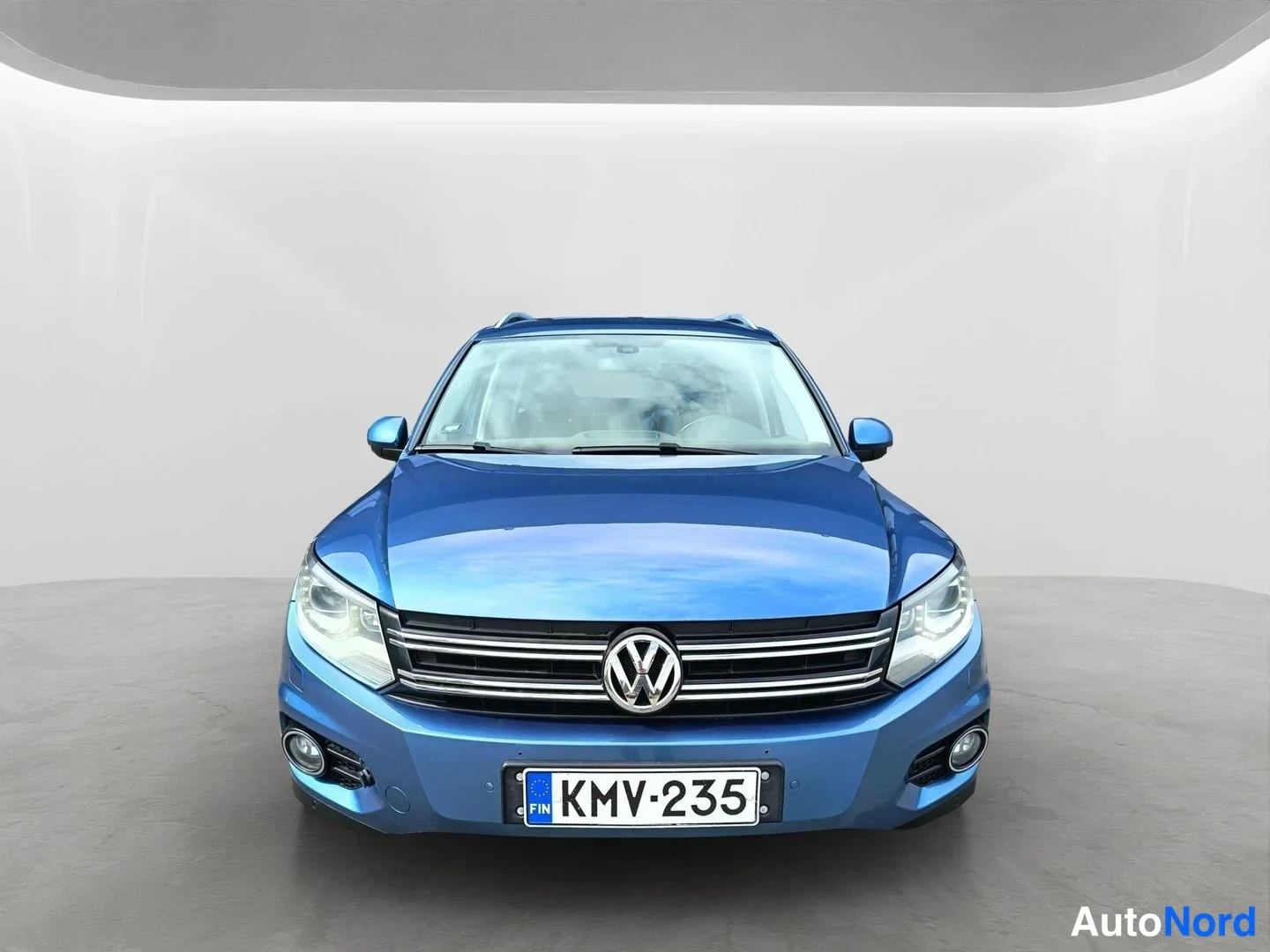 Edestä: Sininen Volkswagen Tiguan suoraan edestä, etumoottorisäleikkö ja.