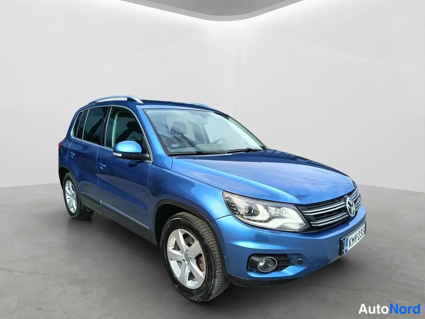 Etuviisto, nokka oikealle: Sininen Volkswagen Tiguan kolmivartalonäkymä edestä oikealta, rekisterikilpi.