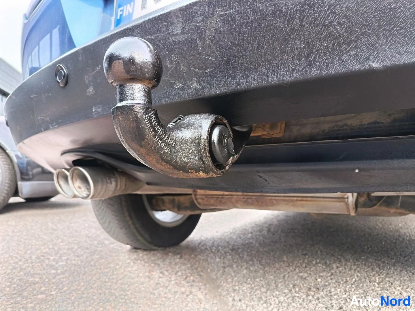 Yksityiskohta: Perävaunun vetokoukku ja kaksiosainen pakoputki auton takapuskurin alla.